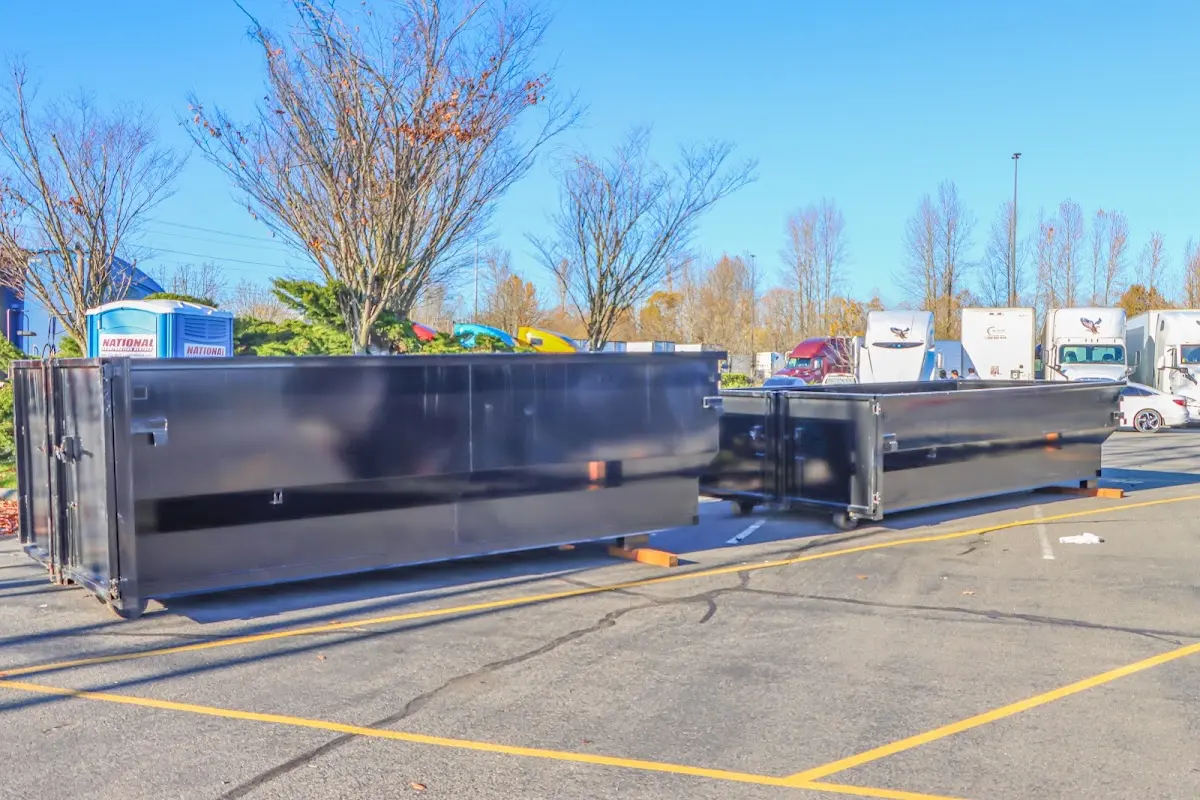 Professional dumpster rental service with roll-off container on residential driveway in East Rancho Dominguez